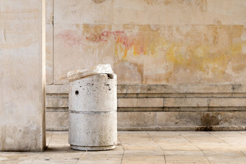 Concrete bin in front of the stone wall.