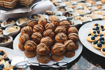 Catering table, beautifully decorated banquet with variety of with different food snacks appetizers on corporate birthday party event or wedding celebration, canape, salad, delicatessen setting

