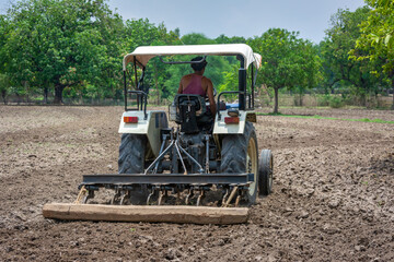 Farmer in tractor preparing land for sowing