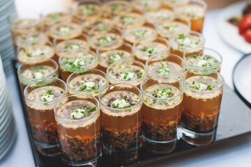 Catering table, beautifully decorated banquet with variety of with different food snacks appetizers on corporate birthday party event or wedding celebration, canape, salad, delicatessen setting
