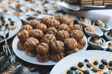 Catering table, beautifully decorated banquet with variety of with different food snacks appetizers on corporate birthday party event or wedding celebration, canape, salad, delicatessen setting
