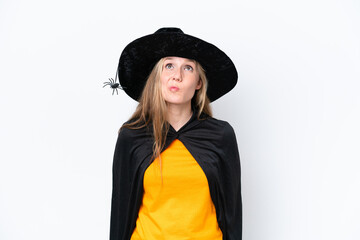 Young blonde woman dressed as a witch isolated on white background and looking up