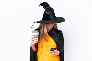 Young blonde woman dressed as a witch isolated on white background holding coffee to take away and a mobile