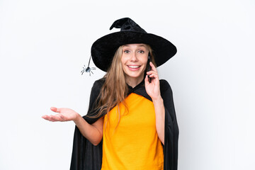 Young blonde woman dressed as a witch isolated on white background keeping a conversation with the mobile phone with someone