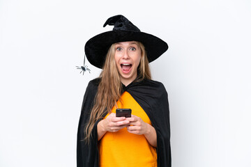 Young blonde woman dressed as a witch isolated on white background surprised and sending a message