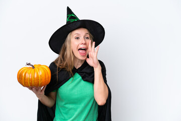 Young blonde woman dressed as a witch holding a pumpkin isolated on white background shouting with mouth wide open to the side
