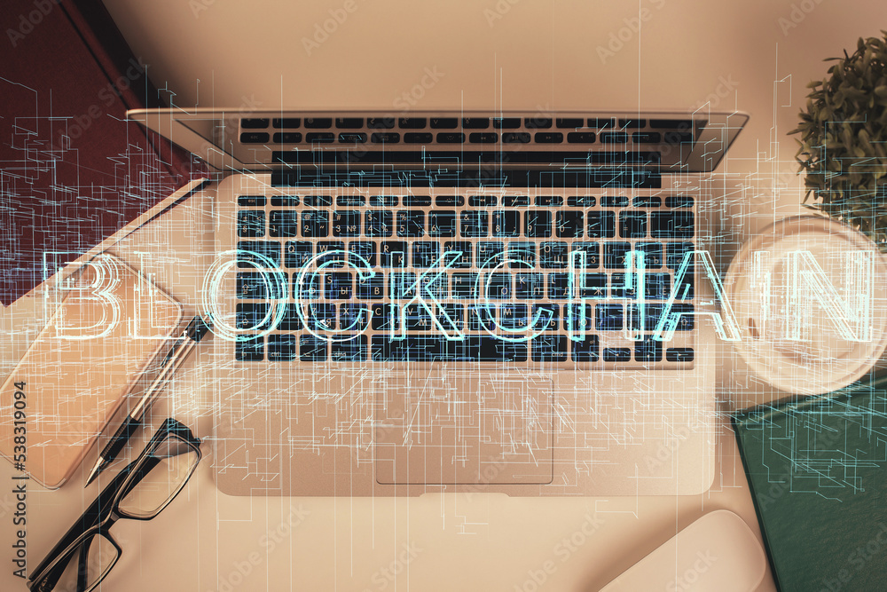 Poster Blockchain theme hologram drawings over computer on the desktop background. Top view. Double exposure.