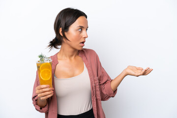 Young hispanic woman holding a cocktail isolated on white background with surprise expression while looking side