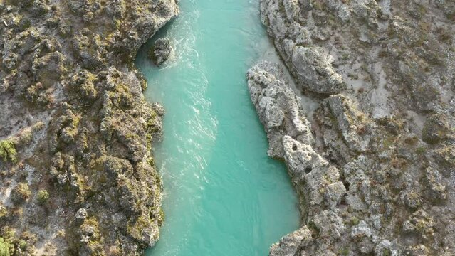 Green mountain river flowing through desolate rocky landscape. Stream bed cut into stones. Texture of rough barren terrain on the banks of turquoise Cijevna (Cem) in Montenegro. Aerial footage.