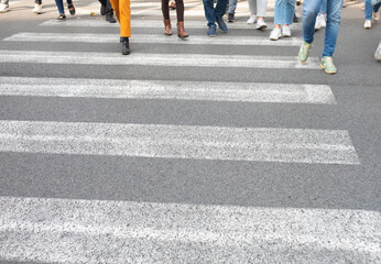 Zebra crossing. Legs of a crowd of busy pedestrians crossing a street.