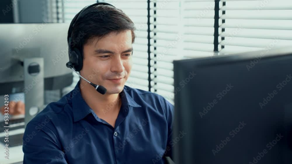 Aufkleber young competent asian male call center agent working at his computer while simultaneously speaking w