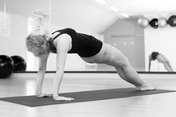 Fototapeta na wymiar Young woman doing yoga exercise in the yoga studio 