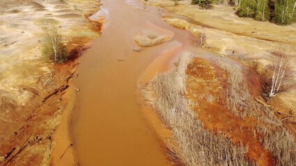 Orange soil is contaminated with heavy metals from an industrial plant. Chemical pollution of soil,...