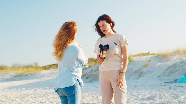 Photographer and model with kid talk on the beach during photo session