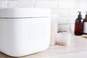 Electric rice cooker on wooden counter-top in the kitchen, closeup of display
