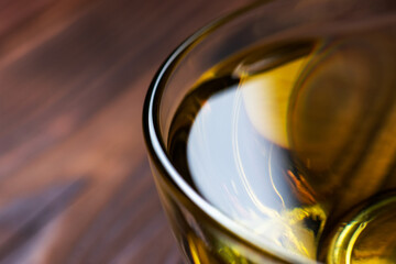 Sunflower oil in glass bowl on wooden boards.