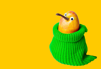 Pear with googly eyes wearing a green sweater