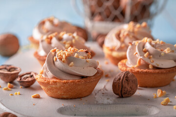 Homemade mini tartlets with vanilla cream and nuts. - obrazy, fototapety, plakaty