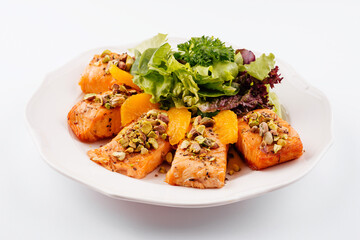 salmon with pistachios, orange slices and lettuce