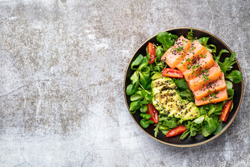 Salmon fish fillet with fresh salad, avocado top view.