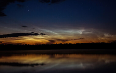 Evening by the lake with noctilucent clouds on a summer night