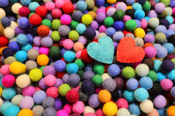 Background of balls of carved wool and two blue and red hearts