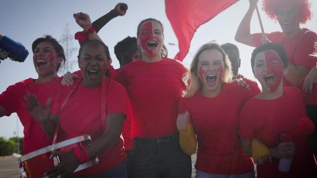 Multiracial red sport football fans celebrating with crowd cheering team on stadium tribune - Soccer spectators watching match game during world championship event