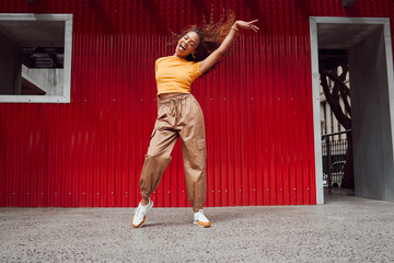 Dance, freedom and fun with a black woman on a red background, dancing or happy with a smile while...