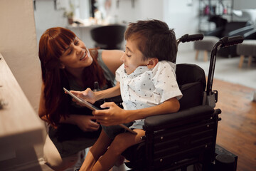 Woman, child disability and tablet, wheelchair friendly and inclusivity, special needs and support. Cerebral palsy and handicap kid, screen time and games, disabled in hairdresser salon.