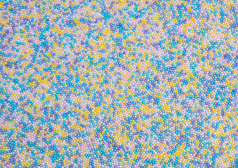 Fototapeta premium background of colorful sprinkles for sweets or beads or small balls. The concept of celebrating a birthday, party or other holidays. trendy, cute background
