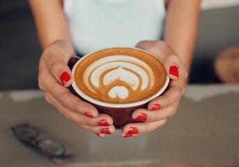 Fototapeta na wymiar Cafe, art and coffee woman hands holding caffeine drink cup for leisure break with top view. Barista, espresso and design of cappuccino beverage of girl customer at restaurant table close up.