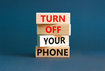 Turn off your phone symbol. Concept words Turn off your phone on wooden blocks. Beautiful grey table grey background. Business, psychological turn off your phone concept. Copy space.