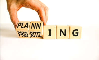 Planning and prioritizing symbol. Concept words Planning and Prioritizing on wooden cubes. Businessman hand. Beautiful white background. Business planning and prioritizing concept. Copy space.