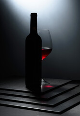 Bottle and glass of red wine.
