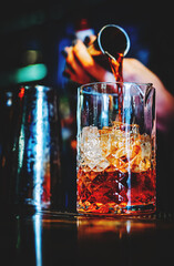 woman hand bartender making negroni cocktail in bar