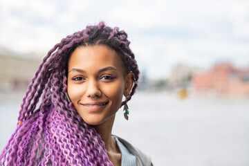 portrait of modern african girl with afro hairstyle outdoor, black girl with purple curls outside