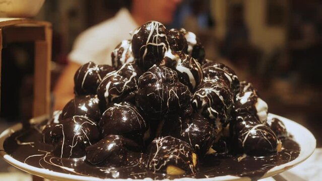 Close up shot of profiterole dessert with choux cream. Pastry ball with sweet and moist filling whipped cream.