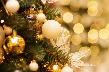 christmas tree with golden magic light bokeh,new year green spruce decorated with balls and stars,...