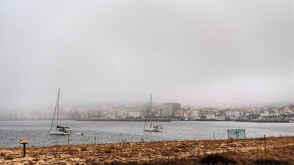 Barcos en la niebla en Coroso, Ribeira, Galicia