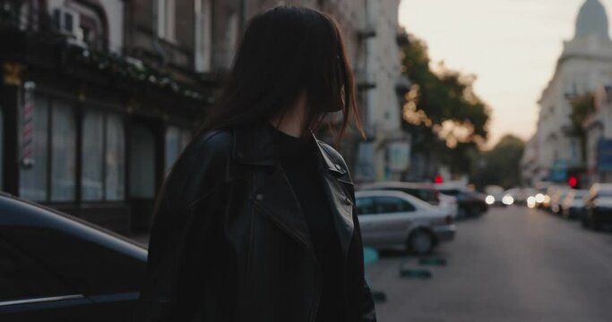 Charming woman walking at the city street turning face back, slow motion
