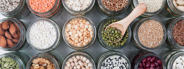 Vegan source of protein. assortment of healthy vegetarian food. top view of seeds, nuts, peas, beans, rice, spelt, oatmeal on white background banner