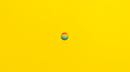 LGTBI multicolored rainbow flag badge, on a yellow background
