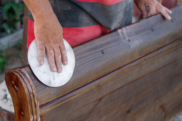 Surface treatment of wood by hand sanding.