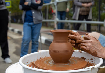 A potter makes a pot on a circle. The hands of the master create from clay. Man making ceramic pot.