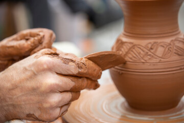 A potter makes a pot on a circle. The hands of the master create from clay. Man making ceramic pot.