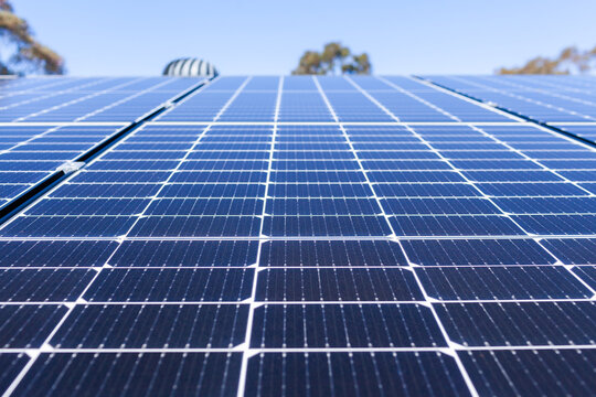 Rows of blue solar panels up to sky on roof of home