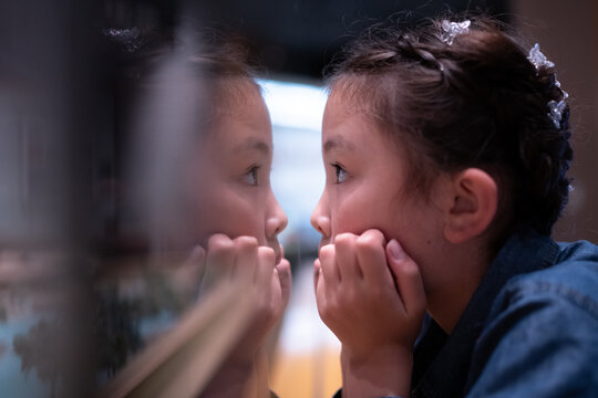 何かを真剣に見る子供と反射する自分自身