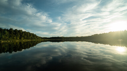 float over the lake and are reflected in the water.