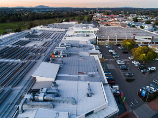Solar panels on roof of shopping centre with carpark beside