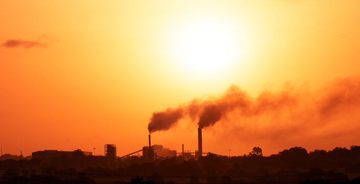 Aerial View Of High Smoke Stack With Smoke Emission. Plant Pipes Pollute Atmosphere. Silhouette Background